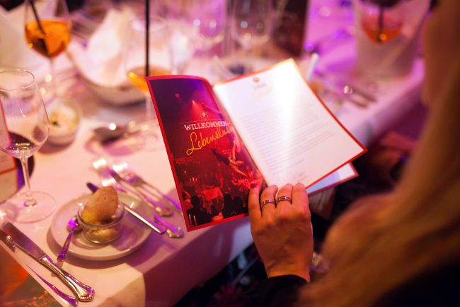 Eine Dame blättert am Tisch im PALAZZO Programmheft.